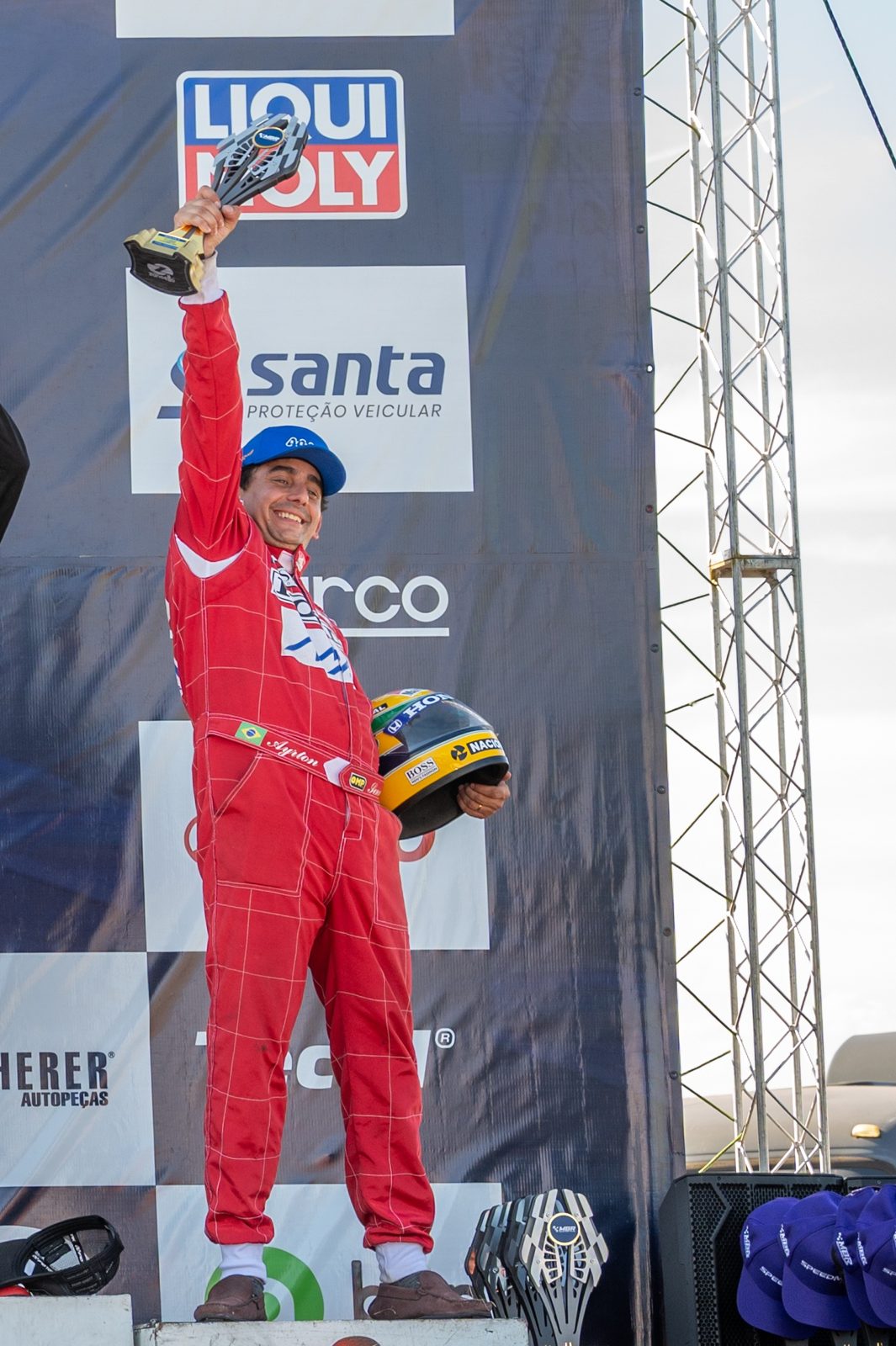 Davi Vianna no topo do pódio, com troféu na mão